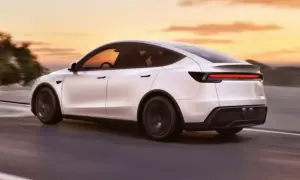 Biała Tesla Model Y jedzie po drodze o zachodzie słońca. Zastanawiasz się, ile waży Tesla Model Y?