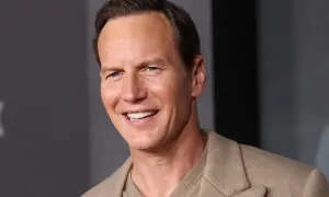 Uśmiechnięty Patrick Wilson, znany z wielu filmów, w beżowej marynarce.
