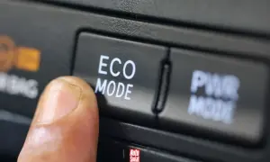 Palec naciska przycisk "ECO MODE", pytając "econ co to?". Obok przycisk "PWR MODE".