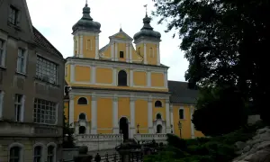 Franciszkowie Poznań wzgórze Przemysła. Żółty kościół z zielonymi kopułami góruje nad miastem.