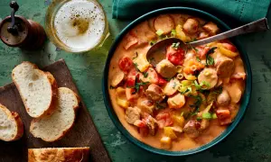 Herzhaftes Wurstgulasch mit Paprika und Tomaten, serviert mit frischem Brot und einem kühlen Bier. Ein tolles Rezept für gemütliche Abende.