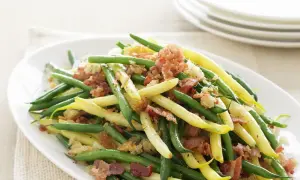 Grüne und gelbe Bohnen mit knusprigem Speck und Croutons. Ein köstliches Gericht, das zeigt, wie man Bohnen kochen kann.