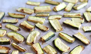 Skivor av zucchini i ugn, lätt gyllene och kryddade, redo att serveras.