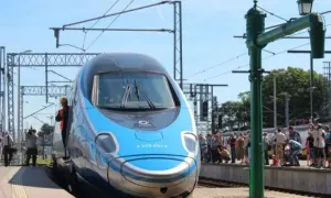 Błękitno-srebrny pociąg EIP, czy to Pendolino? Stoi na peronie, a wokół zgromadził się tłum ciekawskich.