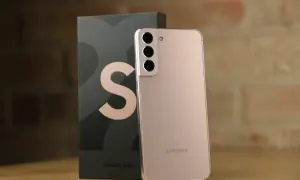 Różowy Samsung S22 Plus obok swojego czarnego pudełka z dużym logo "S".