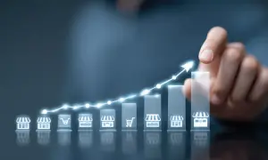 Wykres wzrostu z ikonami sklepów i koszyka, symbolizujący strategię cross selling i rozwój biznesu.