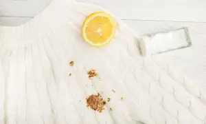 Maglione bianco con macchia di ruggine. Limone e sale pronti per rimuoverla.
