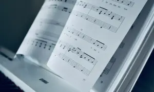Otwarta księga nut na pianinie. Mario, czy ty wiesz, jak zagrać te nuty? PDF z muzyką czeka.