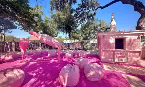 Różowa strefa relaksu z gigantyczną butelką i kieliszkiem prosecco rose, gdzie można usiąść na pufach i napić się różowego napoju.