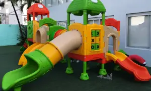 Kolorowy plac zabaw z rurami, zjeżdżalniami i grą kółko-krzyżyk.