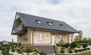 Nowoczesny dom z jasnej cegły, z przestronnym ogrodem i dachem krokwiowo-jętkowym, ozdobionym trzema oknami dachowymi.