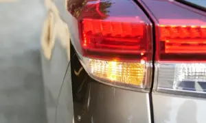 Gros plan sur le feu arrière d'une voiture, le clignotant jaune est allumé, prêt à indiquer un changement de direction.