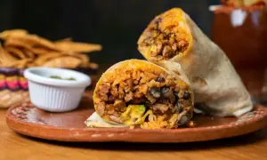 Pyszny farsz do burrito z ryżem, fasolą i mięsem, podany z salsą i chipsami.