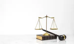 Waga sprawiedliwości, młotek sędziowski i księga prawa. Symbolizują sprawiedliwy proces, który może zadecydować o tym, kto zostanie jedynym spadkobiercą testamentowym.