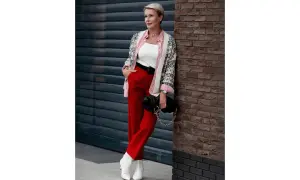 Elegancka kobieta w czerwonych spodniach i wzorzystym kardiganie, prezentująca stylowe czerwone spodnie stylizacje.