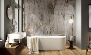 Bagno moderno con vasca freestanding, lavabo sospeso e parete in marmo con venature che si abbinano al legno del pavimento. Idee bagno marmo e legno per un ambiente di lusso.