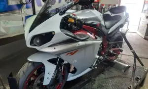 Biały motocykl sportowy na hamowni, przygotowany do **blokowania motocykla na A2**.