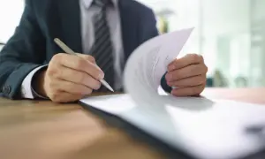 Biznesmen podpisuje dokument, który może być pełnomocnictwem szczególnym.