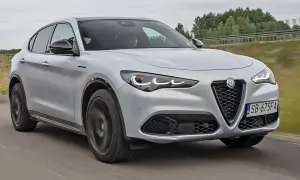 Srebrny Alfa Romeo Stelvio pędzi po drodze, jego sportowy design przyciąga wzrok.