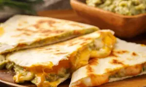 Pyszna kolacja na ciepło: złociste quesadillas z ciągnącym się serem i guacamole. Idealne na szybki posiłek.