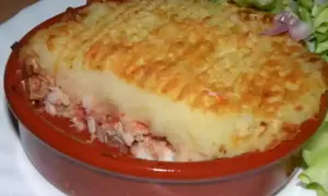 Un parmentier de poisson gastronomique, gratiné et servi avec une salade verte. Un délice réconfortant.