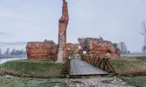 Ruiny zamku w Uniejowie, jedna z ciekawych województwo łódzkie atrakcje, z drewnianym mostkiem prowadzącym do wnętrza.