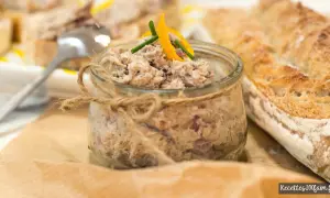 Un pot de rillettes de sardines, garni d'une touche d'agrume et de ciboulette, à déguster avec une baguette croustillante.