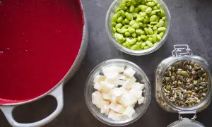 Röd soppa i gryta, edamamebönor, ost och fröblandning. Enkla ingredienser för att leva billigt mat.
