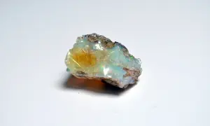 Surowy opal, opalit, mieni się odcieniami zieleni, błękitu i żółci, ukazując swoje magiczne piękno.