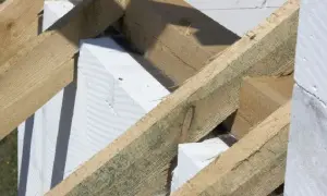 Drewniana konstrukcja dachu z elementami białego betonu komórkowego. To właśnie murłata, co to jest? To belka opierająca się na ścianie szczytowej.