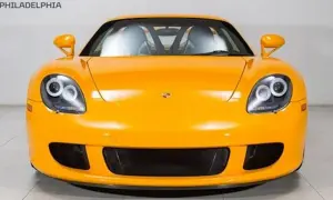 Pomarańczowy Porsche Carrera GT z charakterystycznymi okrągłymi światłami i sportowym grillem.