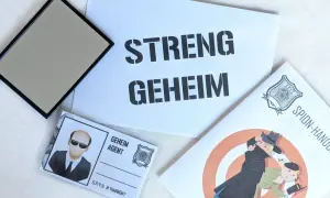 Spannende Detektiv Geburtstag Ideen: Ein Spiegel, ein Ausweis als "Geheim Agent" und eine Broschüre mit dem Titel "Spion-Handbuch" versprechen einen geheimen Missionstag.