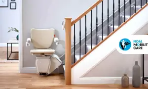 Installazione montascale beige su una scala con corrimano in legno e ringhiera nera. La soluzione ideale per la mobilità in casa.