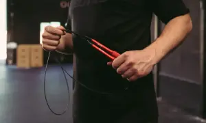 Mann hält ein rotes Springseil. Die richtige Länge ist entscheidend für ein gutes Training.