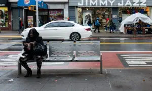 Kobieta siedzi na ławce na ulicy w USA, obok sklepu Jimmy Jazz.