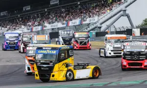 Des camions de course colorés s'affrontent lors d'un grand prix camion, sous les yeux d'une foule en délire dans les tribunes.
