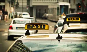 Gelbes Taxi-Schild auf einem Auto in einer Stadt. Ein Taxi in Polen wartet auf Fahrgäste.