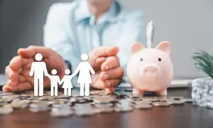 Rodzina na stosie monet, obok świnka-skarbonka. Czy pożyczka może być w gotówce? Finansowe wsparcie dla bliskich.
