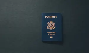 Niebieski paszport USA leży na ciemnym tle. Dokument przypomina o tym, ile ważny jest paszport dla podróżujących.