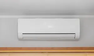 Unità interna di condizionatore bianco montata a parete, con canalina nascosta per un'installazione pulita.