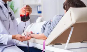 Un médecin prépare une transfusion sanguine pour un patient, une procédure essentielle pour traiter des affections comme la maladie de Biermer.