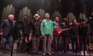 Zespół muzyczny na scenie, w tym Bill Murray w zielonej koszuli, gotowy na koncerty.