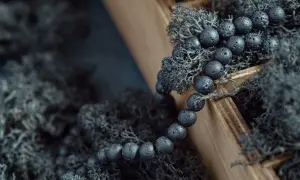 Bransoleta z koralików z lawy wulkanicznej, otoczona mchem. Wierzy się, że lawa wulkaniczna właściwości lecznicze ma od wieków.
