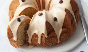 Deliziosa torta al caffè con glassa e chicchi di caffè, una fetta è stata tagliata per mostrare la morbidezza.