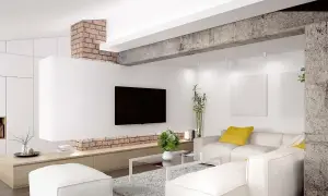 Nowoczesny salon z białym narożnikiem, telewizorem i ceglanym elementem architektonicznym, który pełni funkcję podciągu zamiast ściany nośnej.