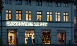 Oświetlony napis "Oliwski Ratusz Kultury" nad wejściami do B&B, Marzeń, Kawiarni i Restauracji.
