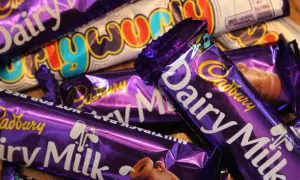 Barras de chocolate Cadbury Dairy Milk y Crunchie, icónicos dulces británicos, apilados en un primer plano.