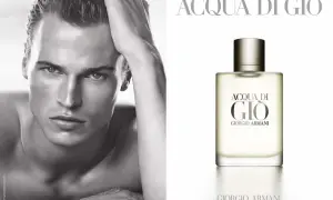Mężczyzna z dłonią na głowie obok flakonu perfum Acqua di Gio Pour Homme Giorgio Armani.