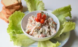 Deliciosa ensalada de cangrejo cremosa, servida con hojas de lechuga fresca y tostadas.