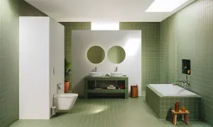 Moderno baño con azulejos verdes, doble lavabo, bañera y WC. Un espacio ideal para renovar el baño con estilo y funcionalidad.